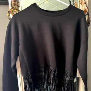 Slightly oversized, cropped black sweatshirt with fringes.